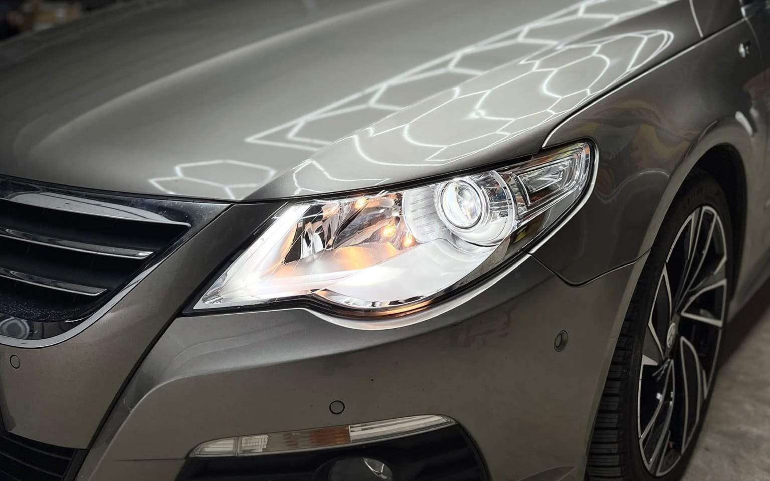 Volkswagen Passat CC în atelier, cu farul aprins: lupă cu lumină albă
