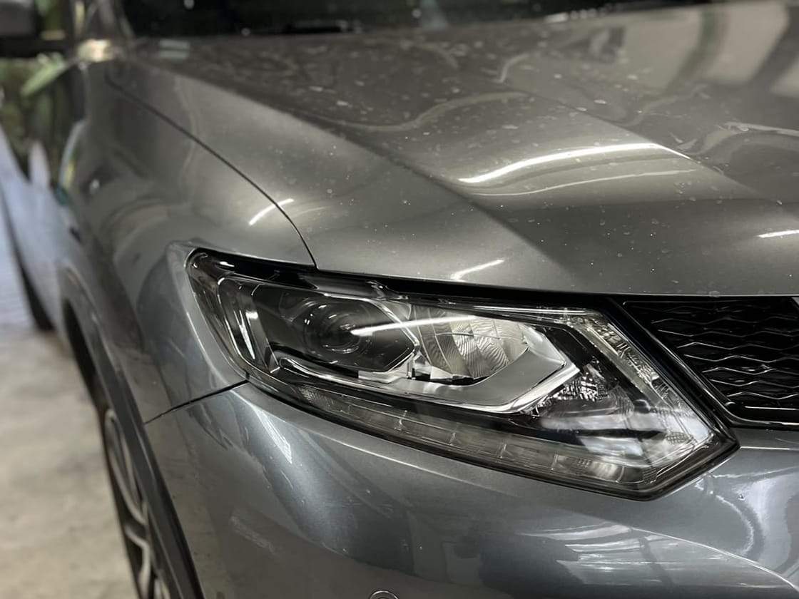 Nissan X-Trail după: sticla farului clară, lupa și luminile de zi vizibile
